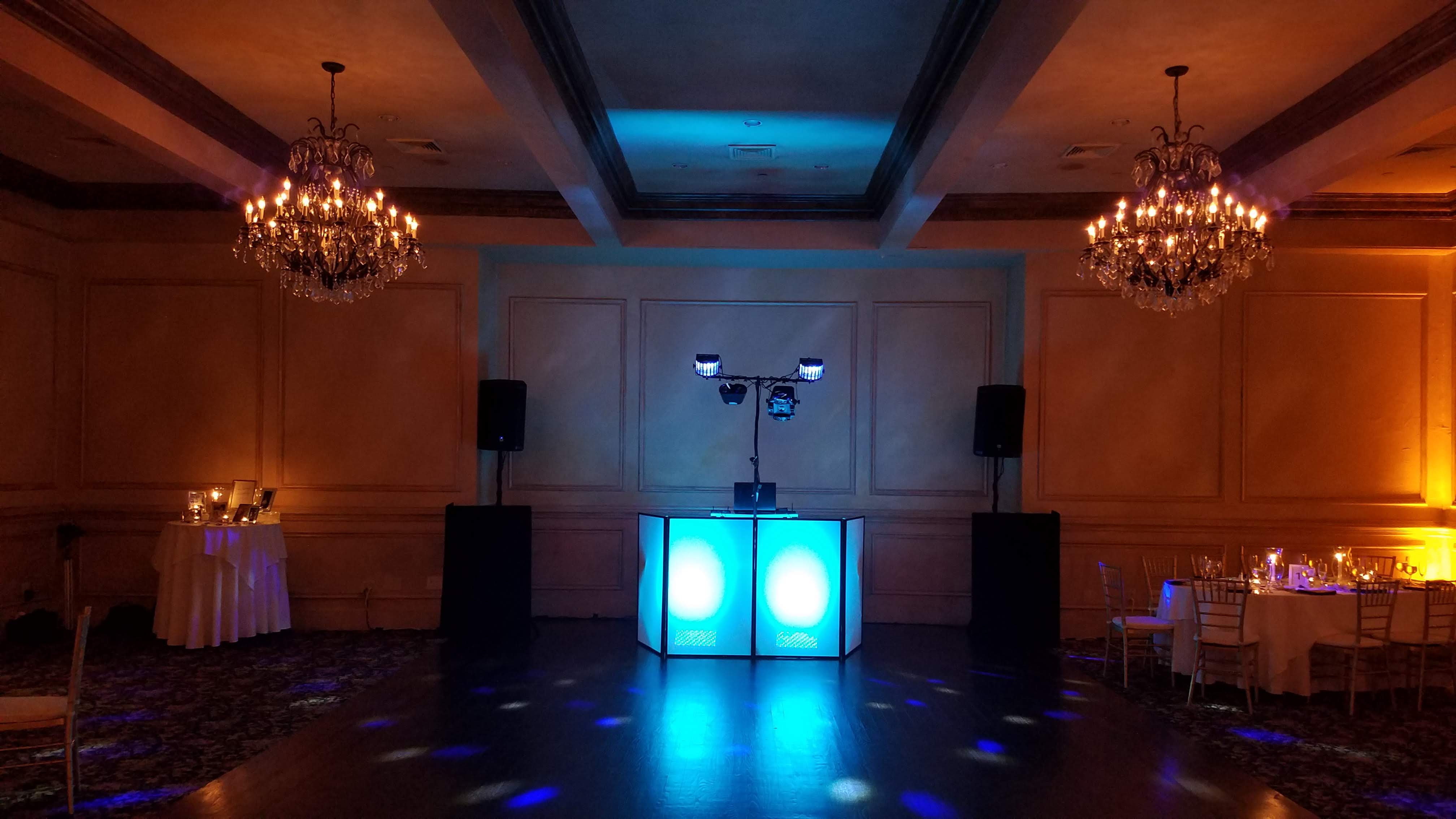 Ballroom with chandeliers and colored uplighting, pre-event