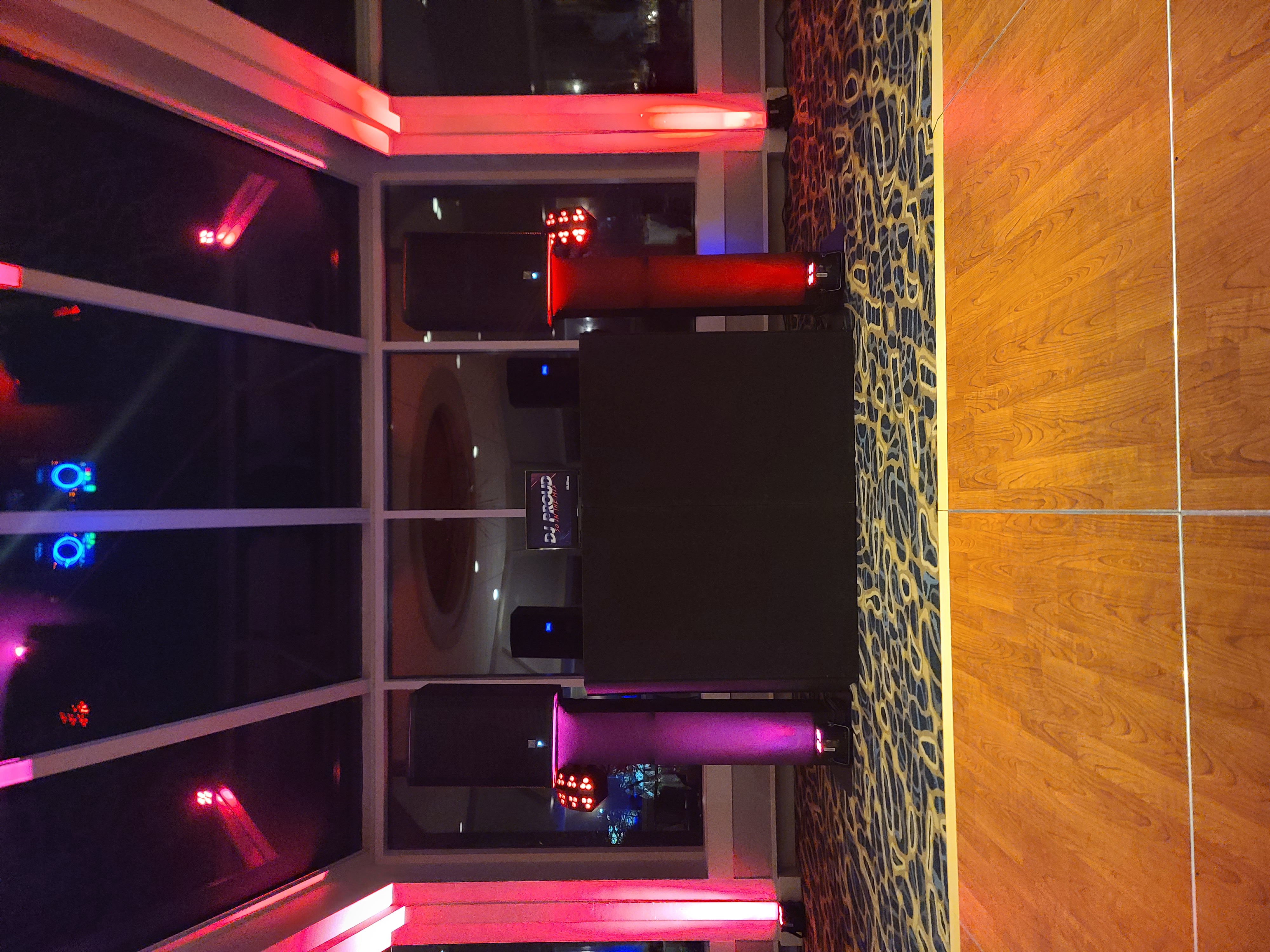 DJ booth glowing under red uplighting at an elegant event
