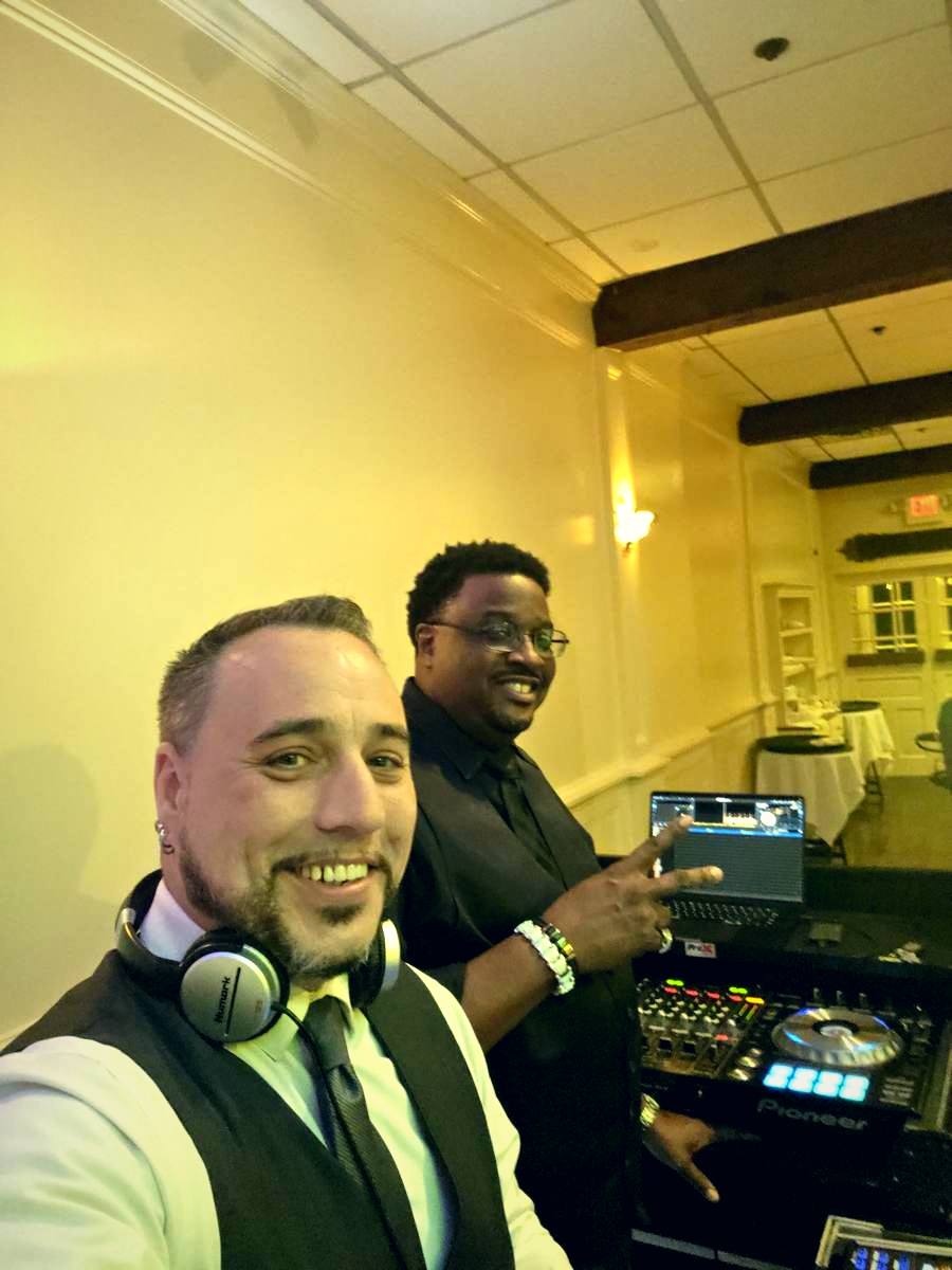 Barry in vest and tie behind the DJ decks