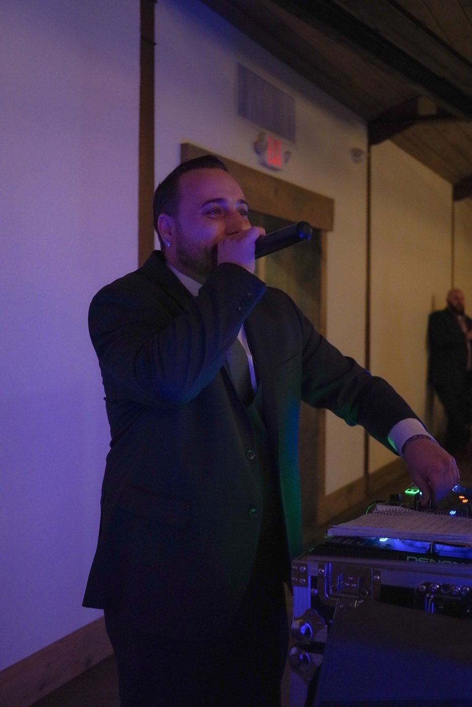 Barry Proud in a full suit on the microphone at a wedding