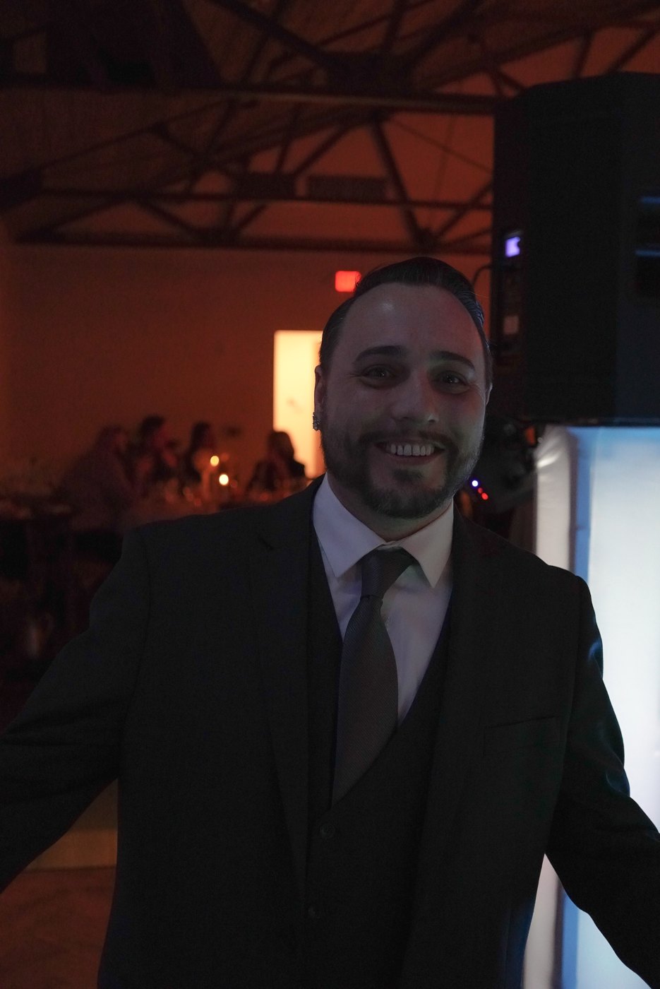 Barry in a dark suit smiling at a wedding reception