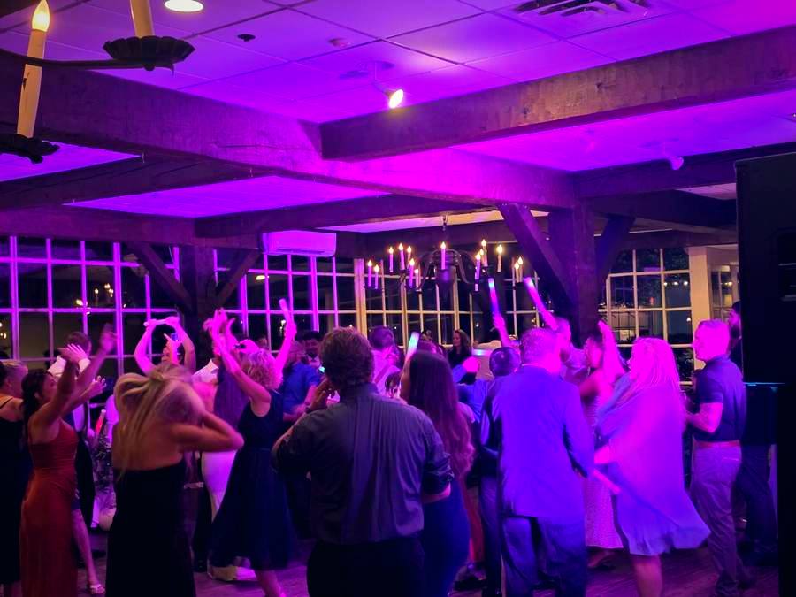Packed dance floor under purple uplighting