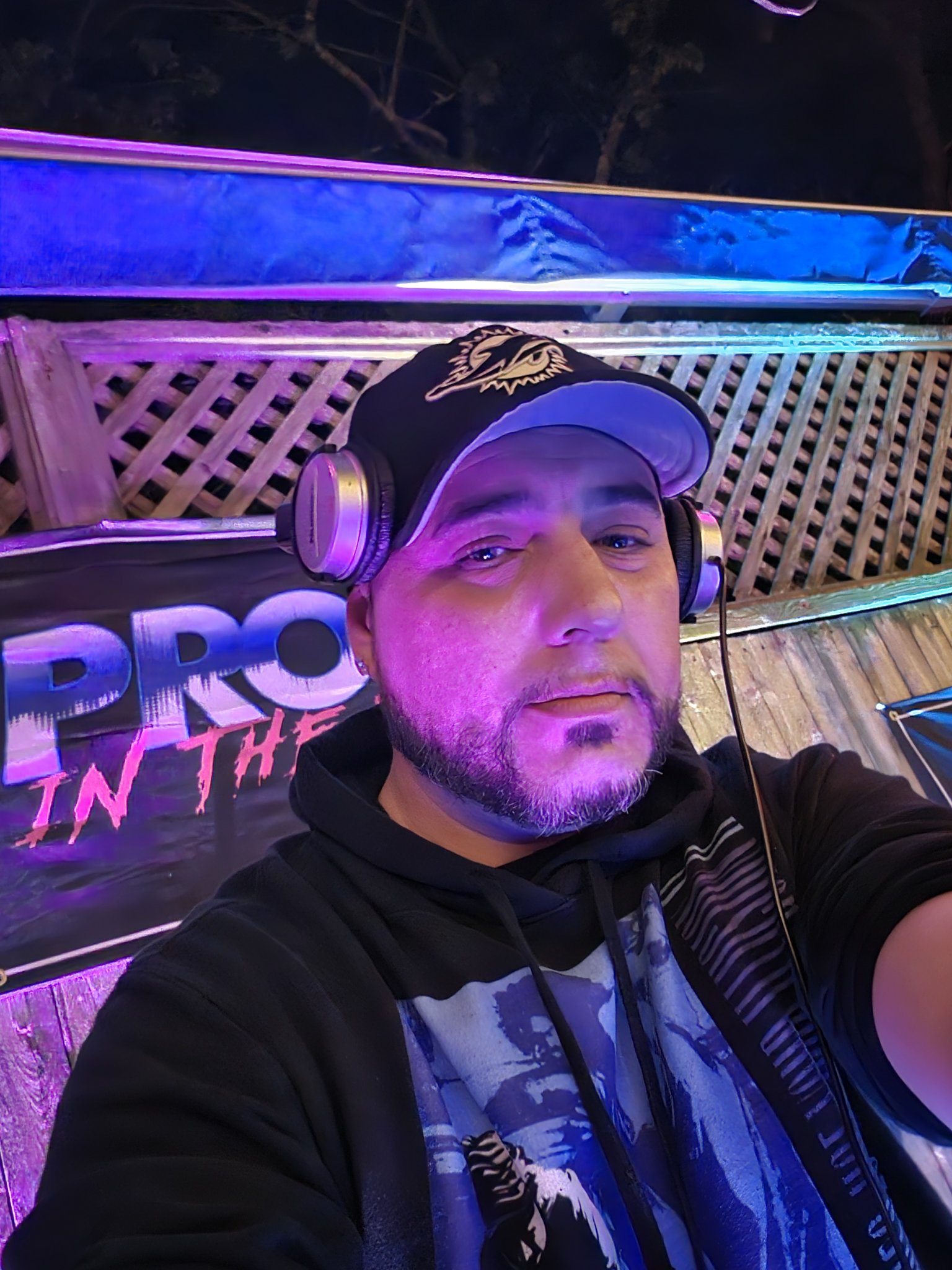 Barry from the DJ booth at a night tent party — packed crowd under purple lights