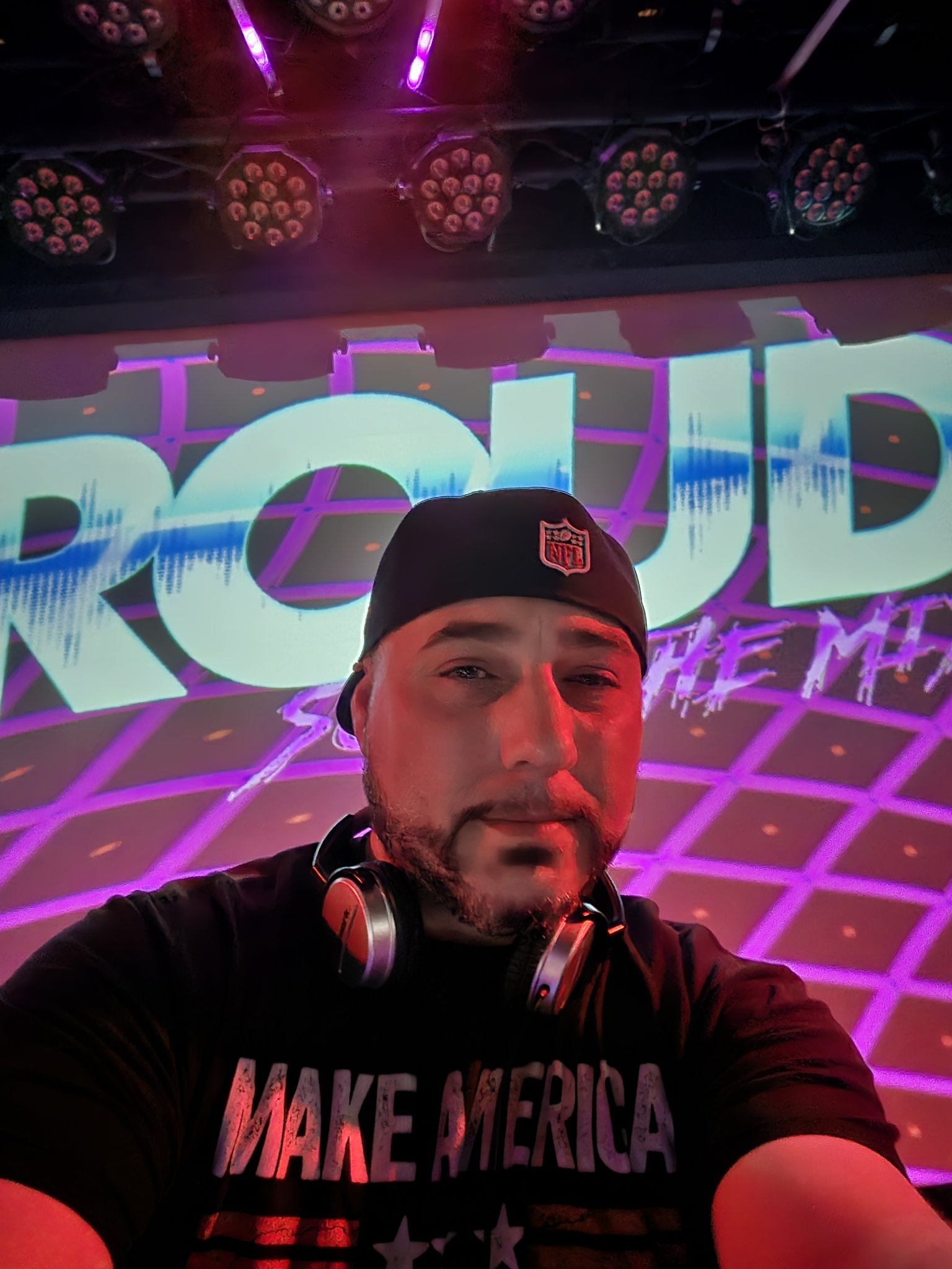 Barry in front of a glowing PROUD — so in the mix LED wall at a club