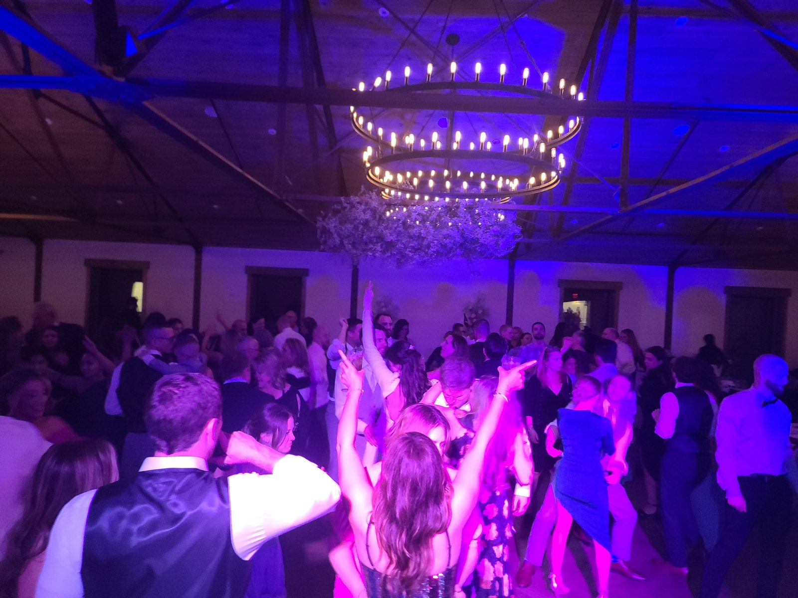 Wedding crowd with hands up on a packed dance floor