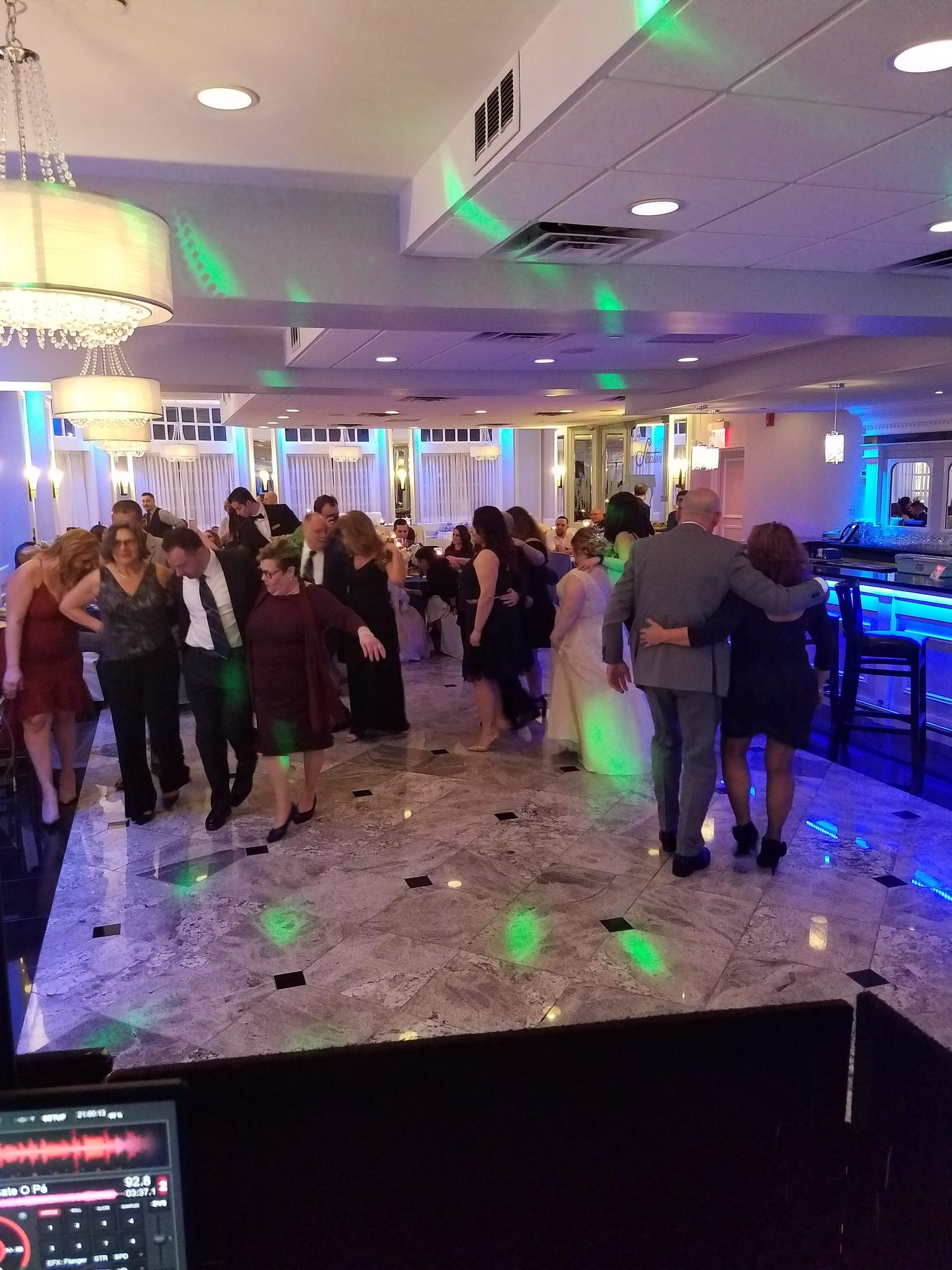 Wedding dance floor bathed in colored light with the crowd dancing