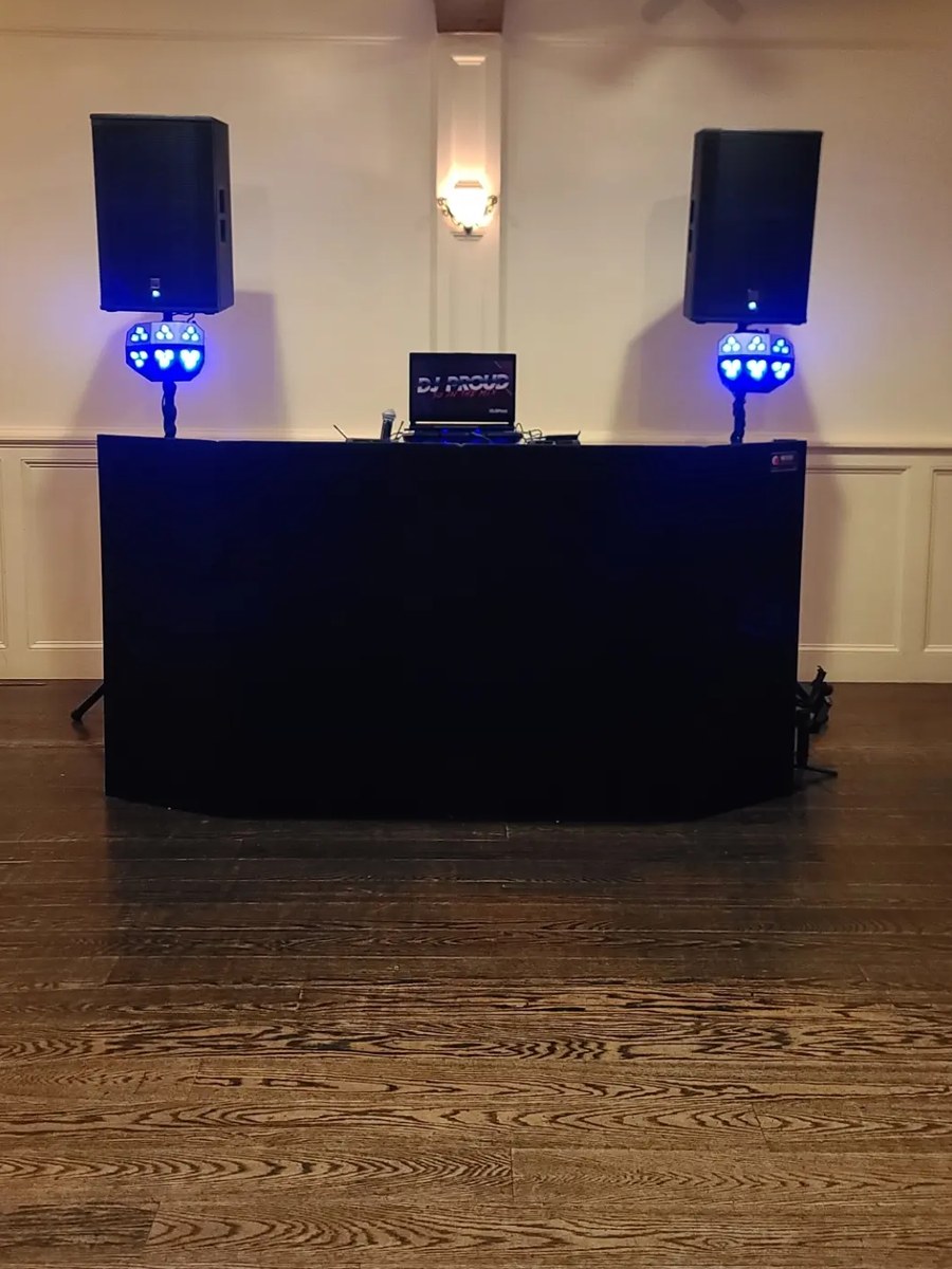 The Proud black DJ setup — black facade, two speakers and dance-floor lights, no totems
