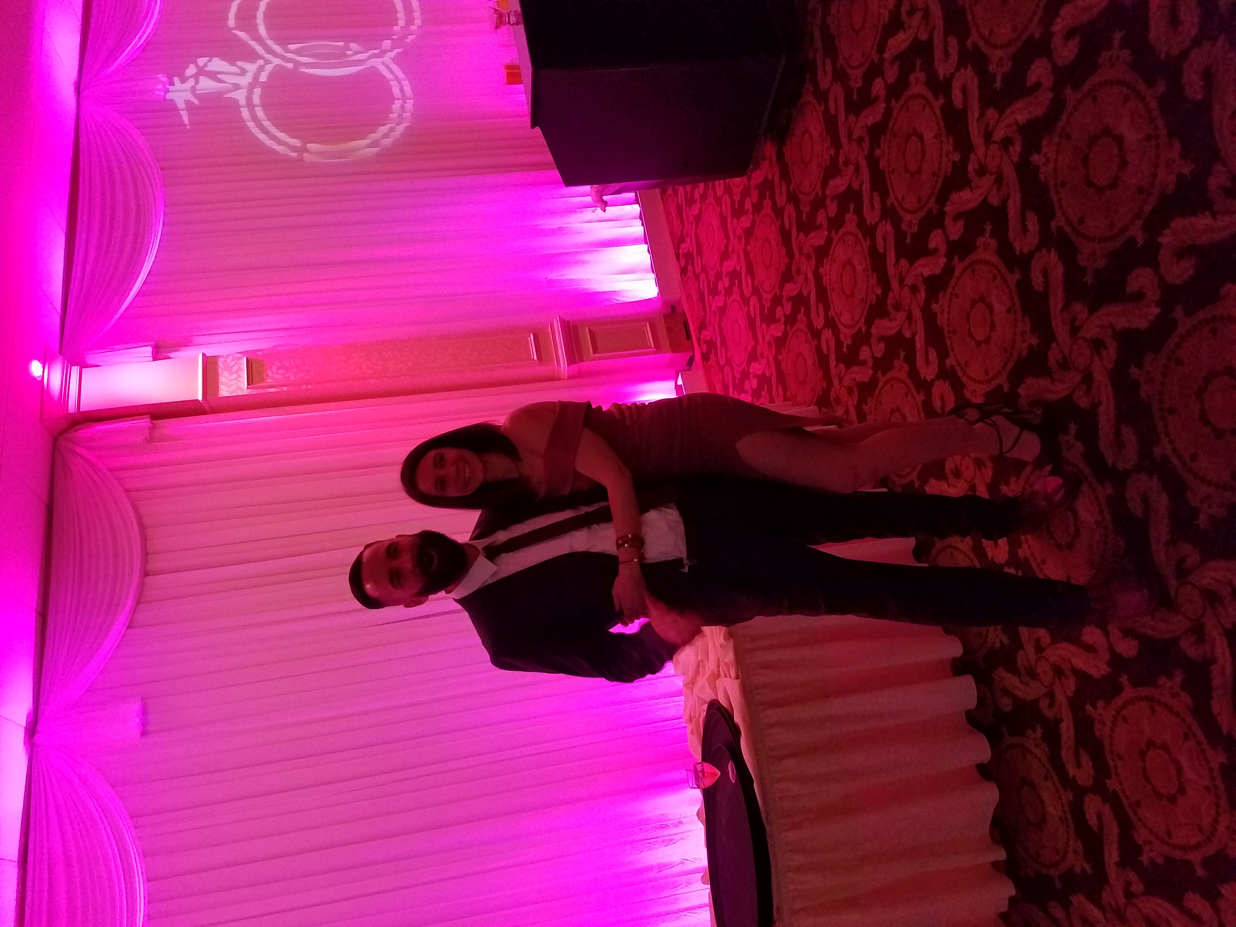 Newlywed couple on the dance floor under a projected monogram