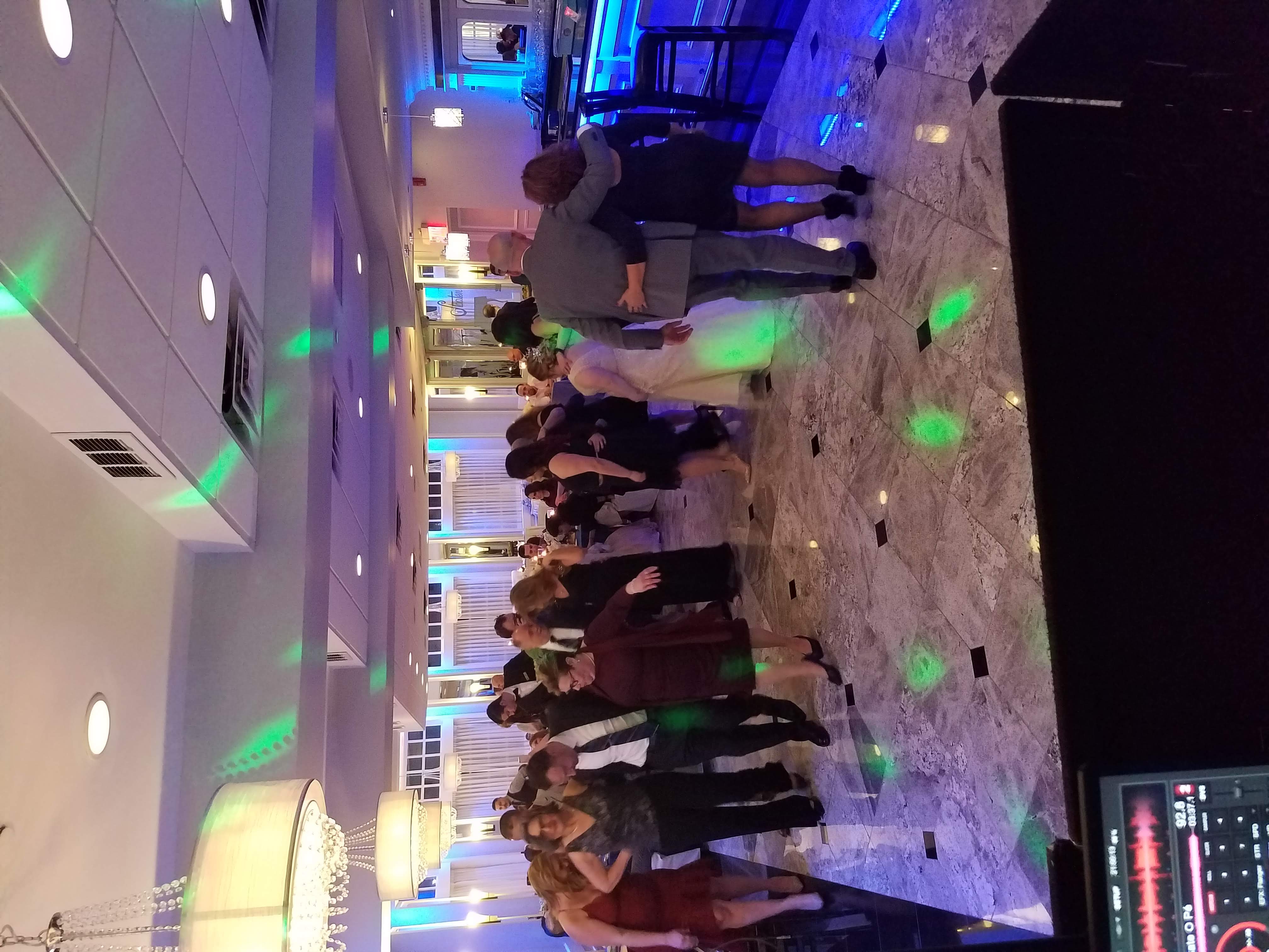 Wedding crowd dancing under green and blue light