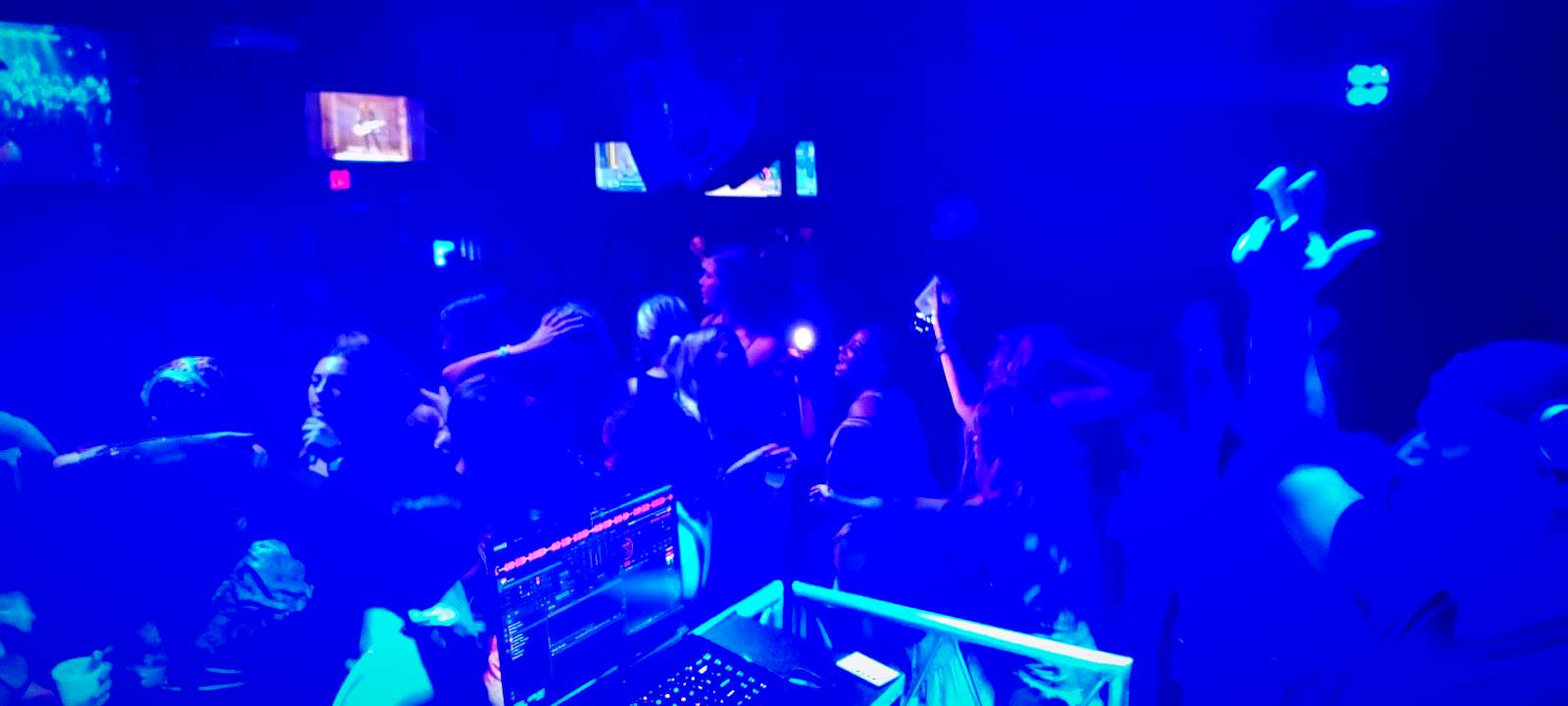 Packed nightclub floor under blue lighting